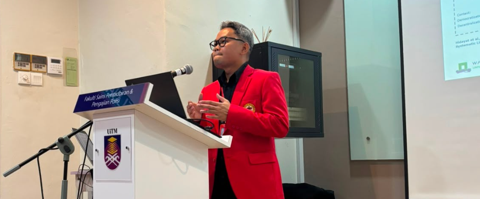 Speaker in red blazer at podium presentation