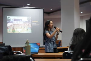 Woman giving presentation with microphone in classroom