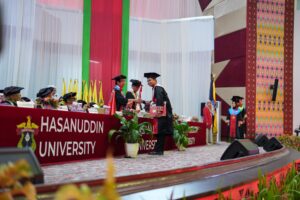 Graduate shaking hands at university commencement ceremony