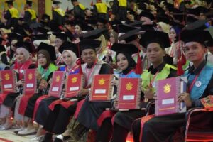 Graduates holding diplomas at commencement ceremony