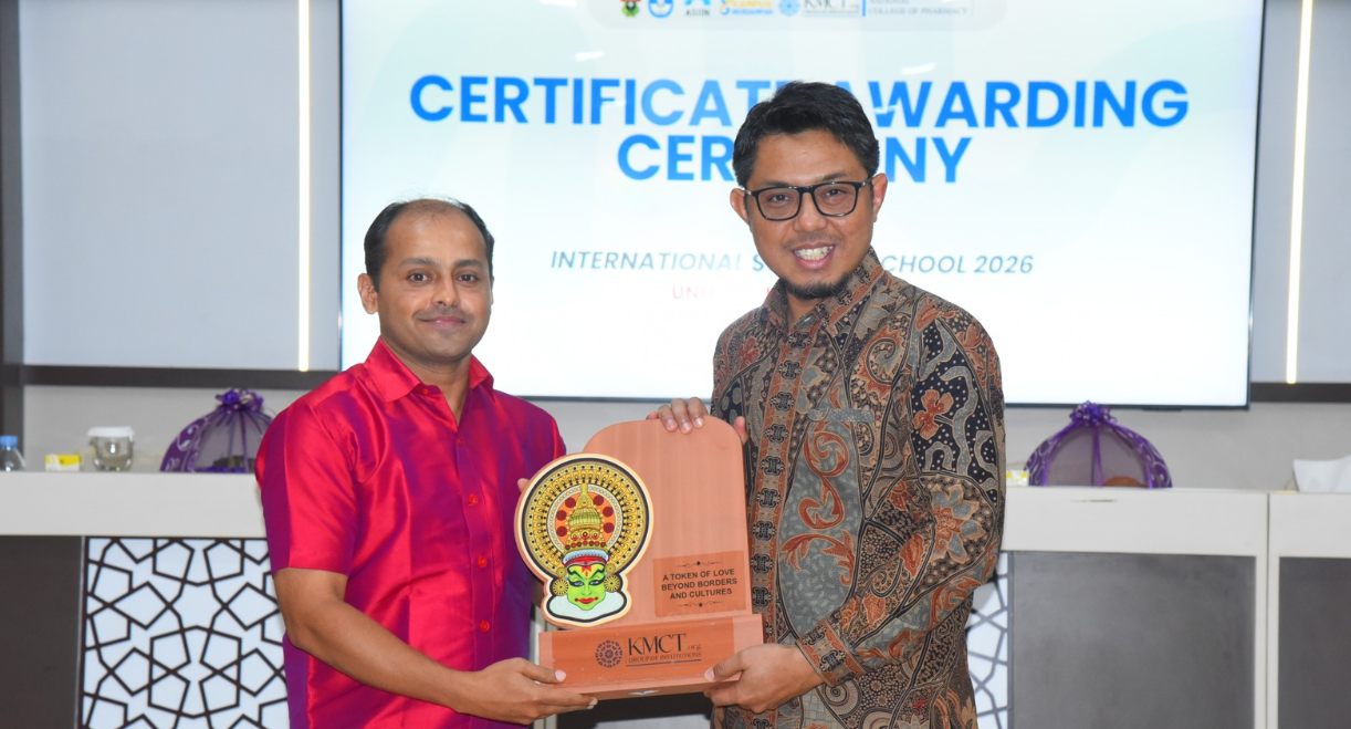 Two men holding award plaque at ceremony