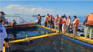 Visitors in life jackets at offshore fish farm