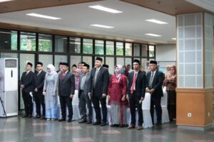 Sejumlah pejabat berdiri dalam acara resmi indoor