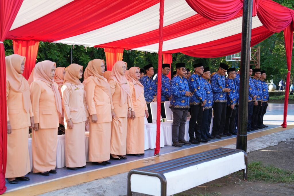Pejabat berdiri di bawah tenda merah putih