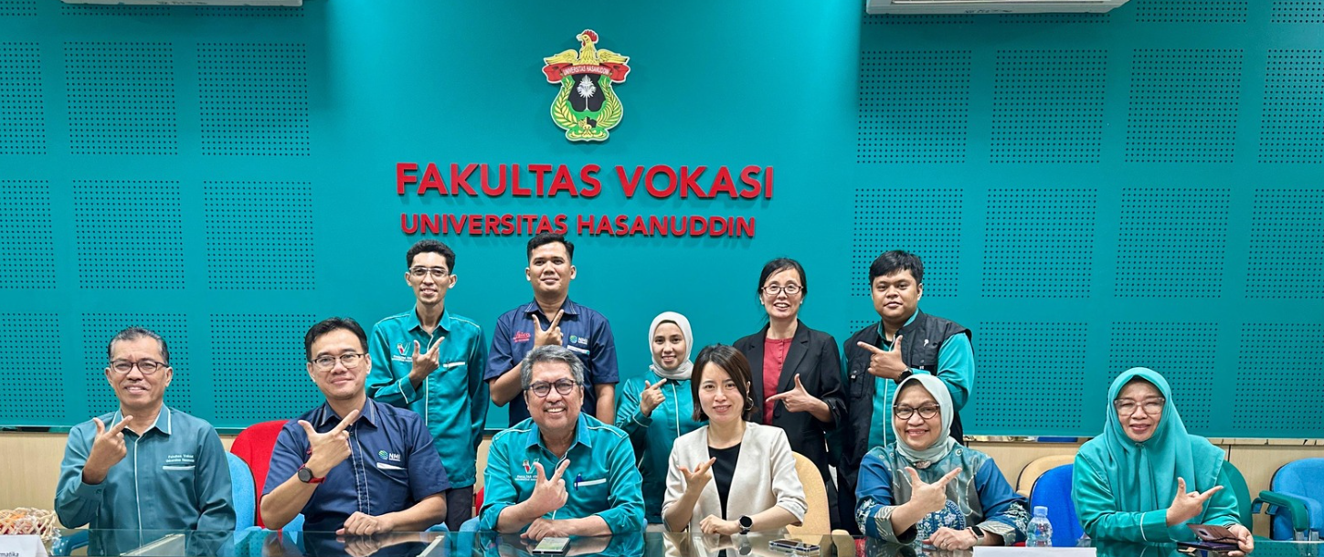 Faculty group posing at Universitas Hasanuddin meeting room