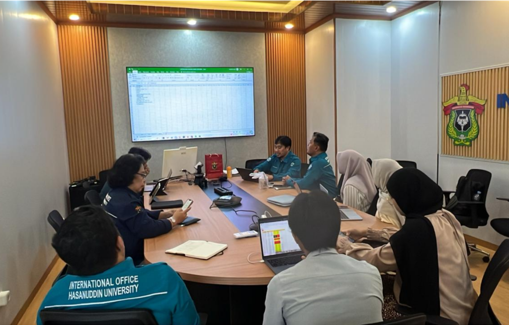University staff meeting reviewing spreadsheet on screen