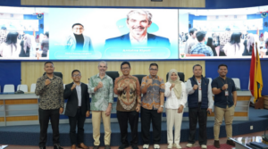 Group posing at conference with large presentation screen