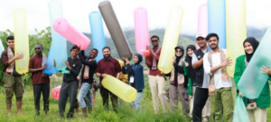 Group holding giant colorful inflatable tubes outdoors