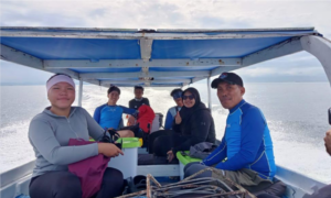 Group riding small motorboat on open water