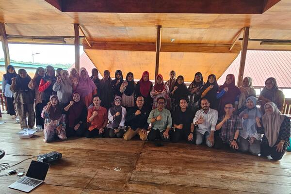 Kelompok orang berfoto di panggung kayu