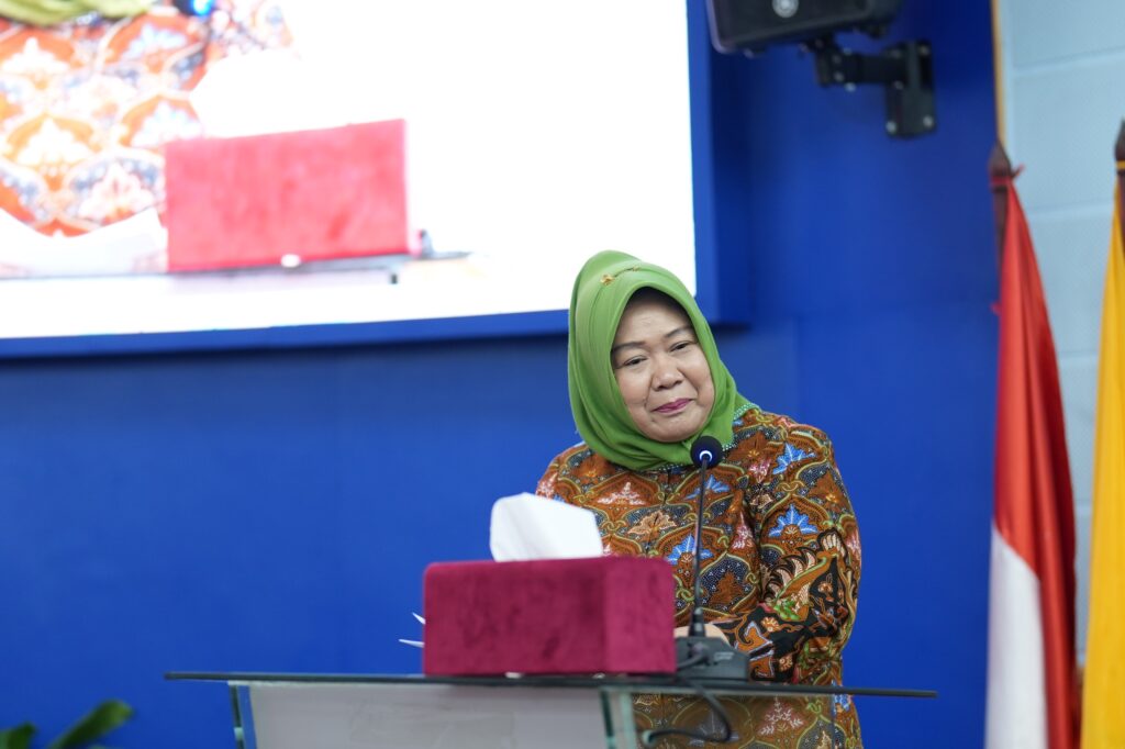 Woman in green hijab speaking at podium