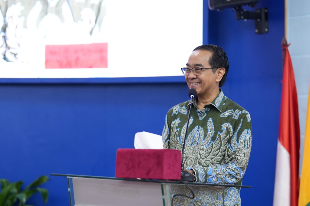 Man in batik shirt speaking at podium