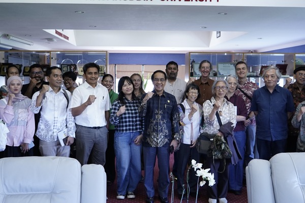 Sekelompok orang berpose bersama di dalam ruangan