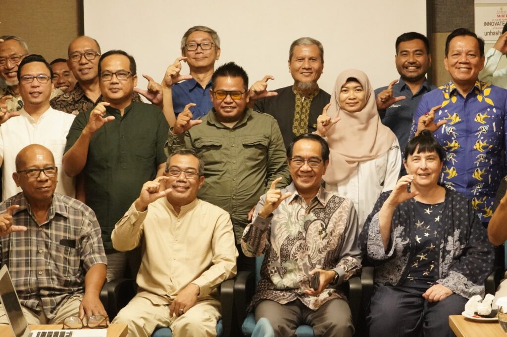 Group of adults posing with C hand gesture