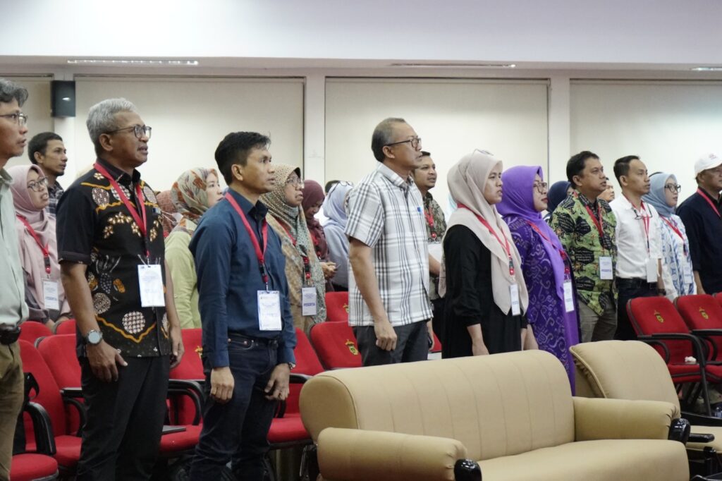 Conference attendees standing during formal indoor event
