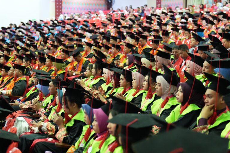 Graduates seated at indoor commencement ceremony