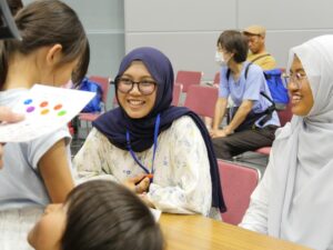 Women in headscarves smiling with children indoors