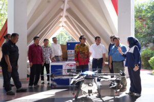 Pejabat meninjau drone pertanian di dalam gedung