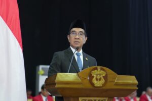Pejabat berpeci berpidato di podium resmi