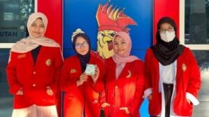 Empat mahasiswi berjas merah berpose bersama