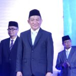 Pria bersetelan jas dan peci di acara resmi