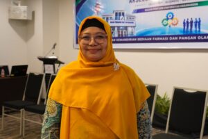 Perempuan berhijab kuning di ruang seminar