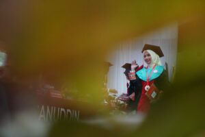 Wisudawati berhijab melambaikan tangan saat wisuda