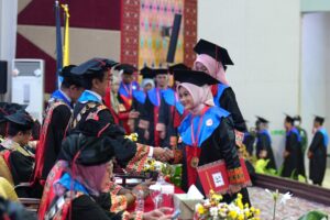 Mahasiswi wisuda berjabat tangan dengan rektor