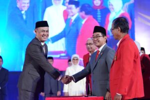 Pejabat berjabat tangan di acara resmi