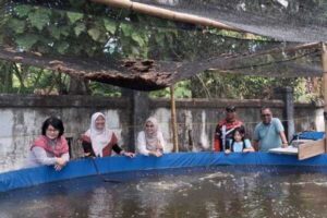 Sekelompok orang di kolam budidaya ikan