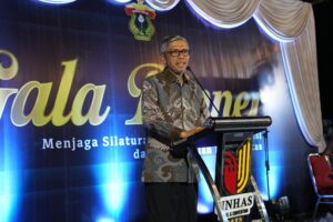 Pria berbatik berpidato di podium acara resmi