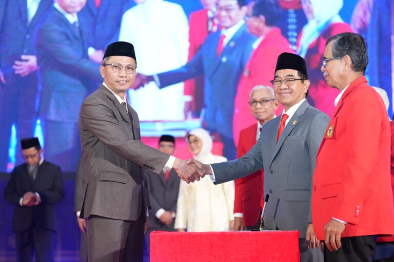 Pejabat berjabat tangan dalam acara resmi