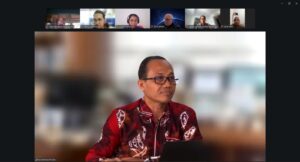 Pria berbaju batik merah dalam rapat daring