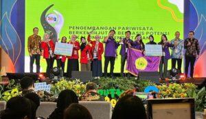 Pemenang menerima penghargaan pariwisata di atas panggung