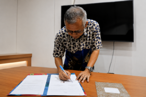 Man signing documents at a conference table