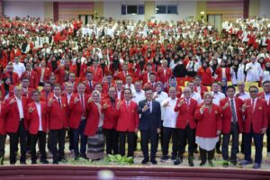 Foto bersama peserta berjas merah dan putih di auditorium