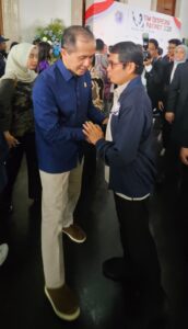 Dua pria berjabat tangan di acara resmi