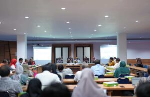 Peserta menghadiri rapat di ruang konferensi