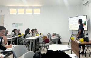 Mahasiswi mempresentasikan materi di depan kelas