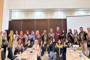 Kelompok peserta berfoto di ruang rapat