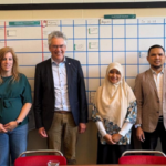 Six colleagues standing in front of planning board
