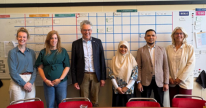 Six colleagues standing in front of planning board