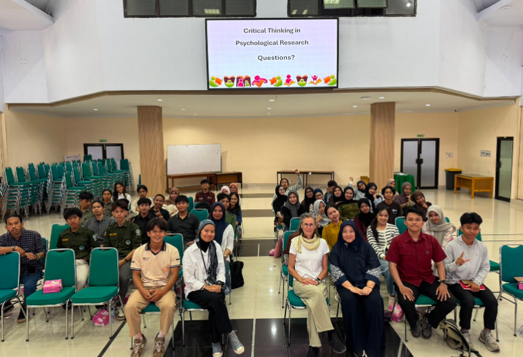 Students seated in lecture hall under presentation screen