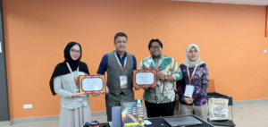 Four adults holding certificates at indoor event