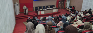 Speaker addressing audience in large lecture hall