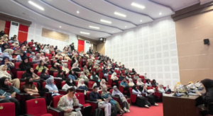 Audience seated in large auditorium during lecture