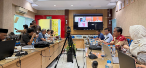 Conference room meeting with video call on screen