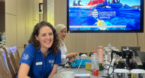 Two women at university presentation table indoors