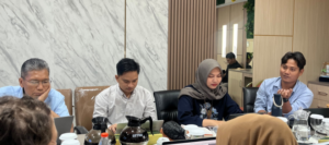Group meeting at conference table with coffee and laptops