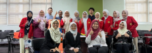 Group of students posing in classroom with thumbs up